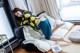 A woman laying on a bean bag chair in front of a window.