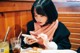 A woman sitting at a table looking at her phone.