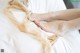 A woman's bare feet on a bed with a white sheet.