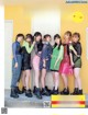 A group of girls standing next to each other in front of a yellow wall.